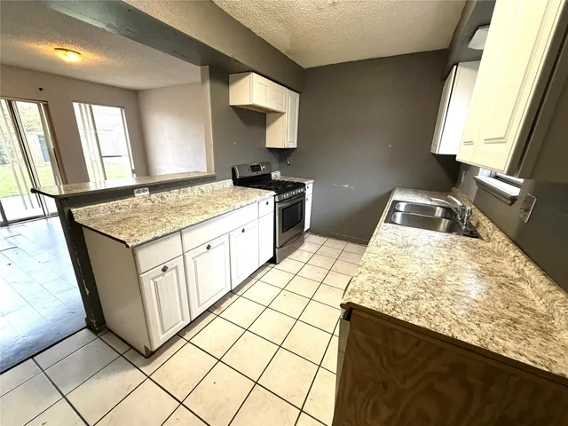 a kitchen with a sink stove and mirror