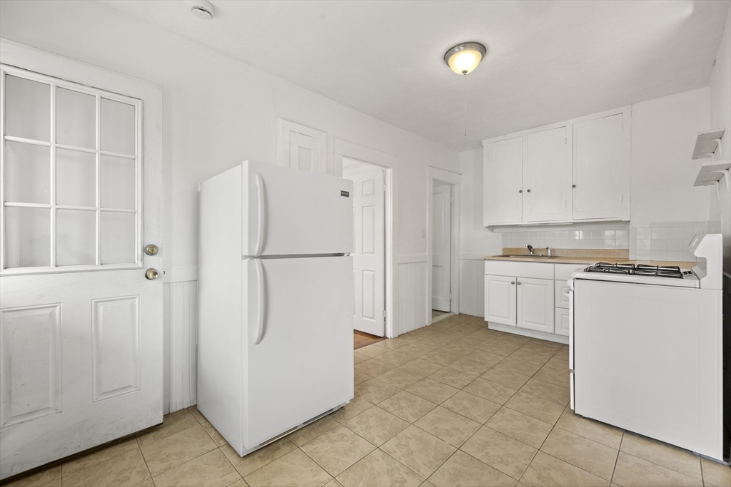 20-22 Sumner Street, Unit 202 Quincy, MA 02169 - Photo 7 of 15 a kitchen with white cabinets and white appliances