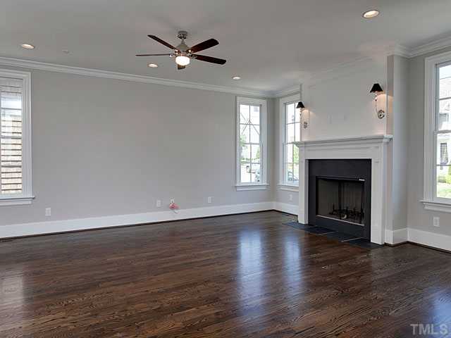 2012 Vinnings Place Raleigh, NC 27608 - Photo 4 of 25 an empty room with wooden floor fireplace and windows
