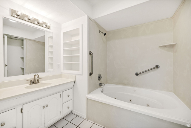 4155 Johnson Road Nibley, UT 84321 - Photo 20 of 71 Bathroom featuring vanity, built in shelves, light tile patterned floors, and a combined bath / shower with jetted tub