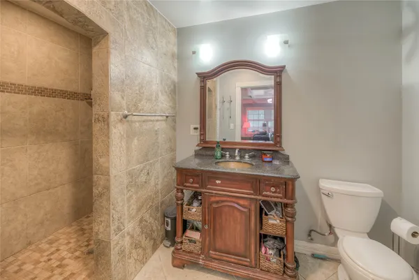 a bathroom with a toilet a sink and mirror