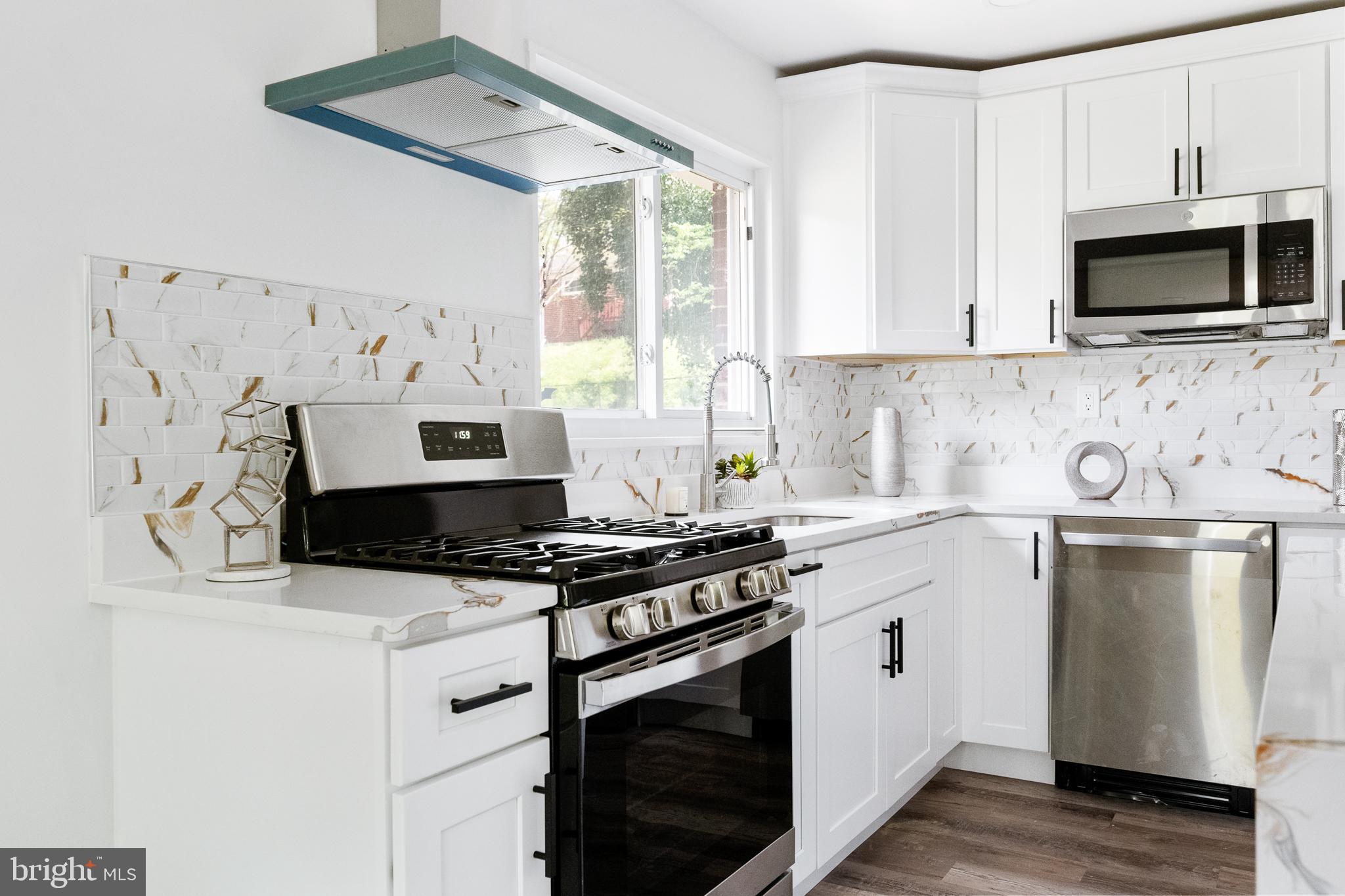 6907 Kipling Parkway District Heights, MD 20747 - Photo 11 of 39 a kitchen with stainless steel appliances a stove a microwave and cabinets