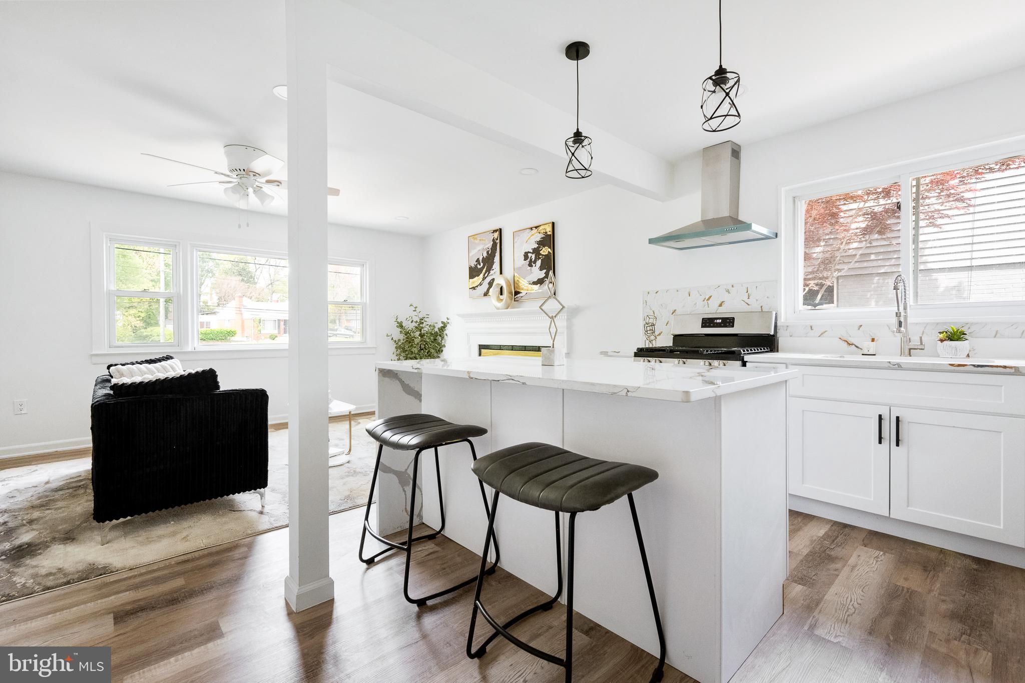 6907 Kipling Parkway District Heights, MD 20747 - Photo 13 of 39 a kitchen with stainless steel appliances kitchen island granite countertop a refrigerator a stove a sink dishwasher and white cabinets with wooden floor