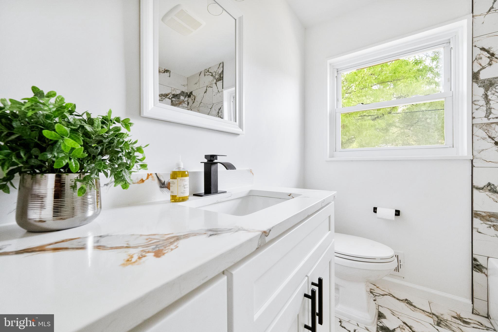 6907 Kipling Parkway District Heights, MD 20747 - Photo 18 of 39 a bathroom with a sink a toilet and a window