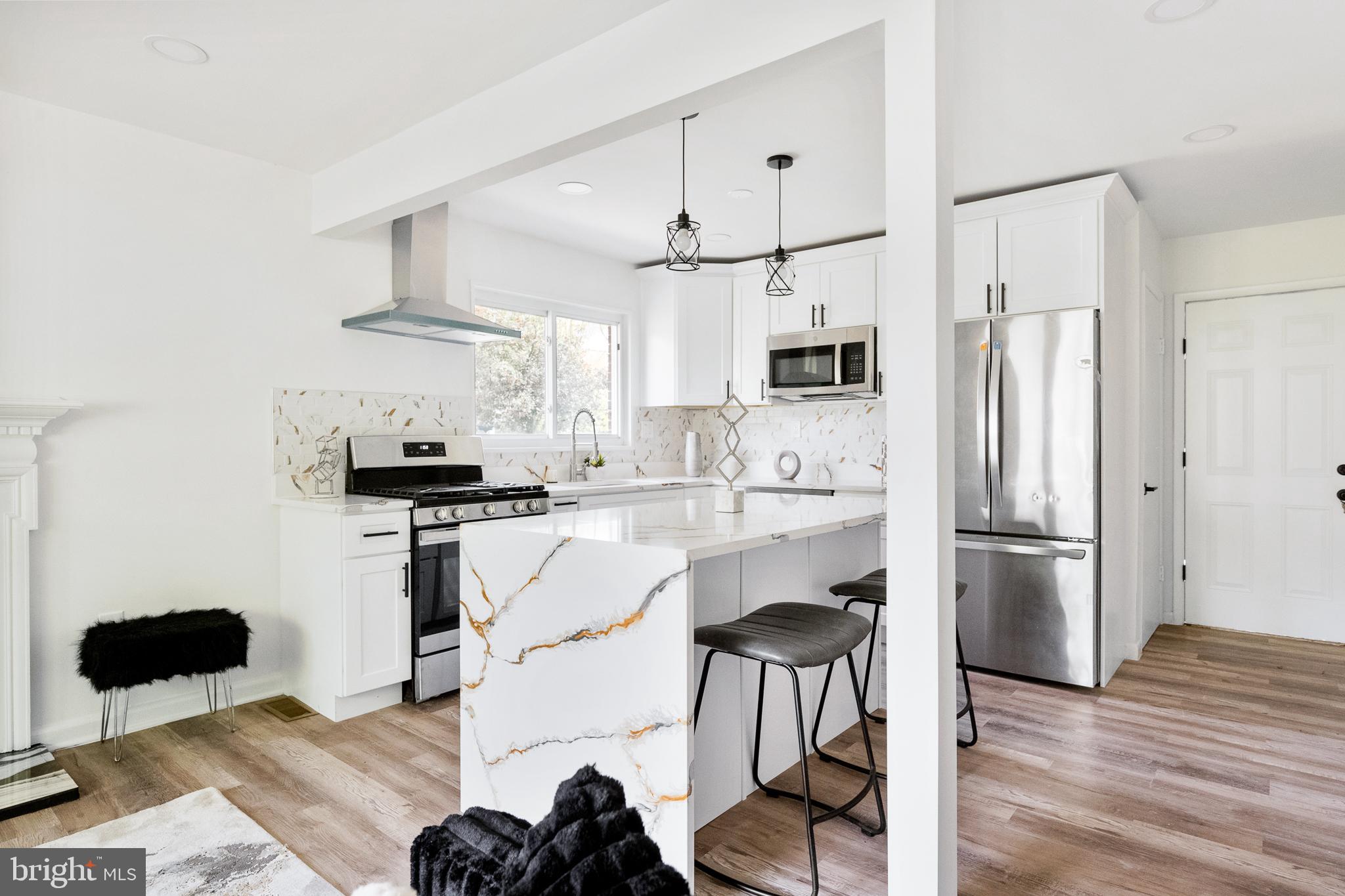6907 Kipling Parkway District Heights, MD 20747 - Photo 8 of 39 a kitchen with stainless steel appliances kitchen island a refrigerator and a stove top oven