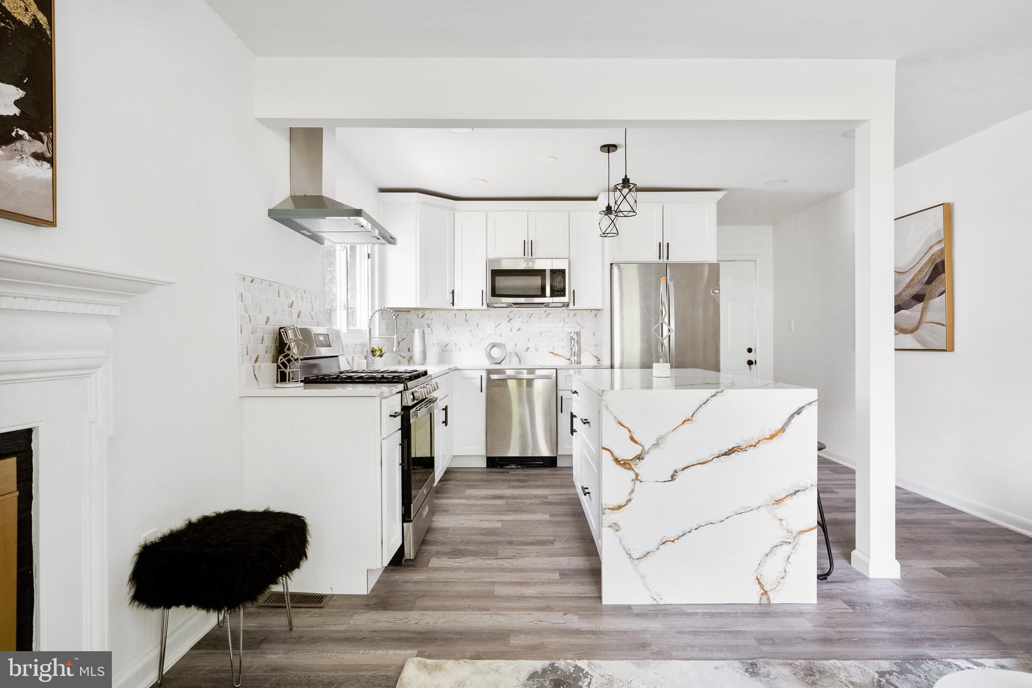 6907 Kipling Parkway District Heights, MD 20747 - Photo 10 of 39 a kitchen with stainless steel appliances kitchen island granite countertop a refrigerator and a stove top oven