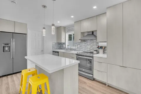 a kitchen with kitchen island a stove a sink and a refrigerator