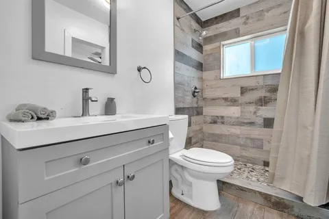 a bathroom with a sink a toilet and mirror