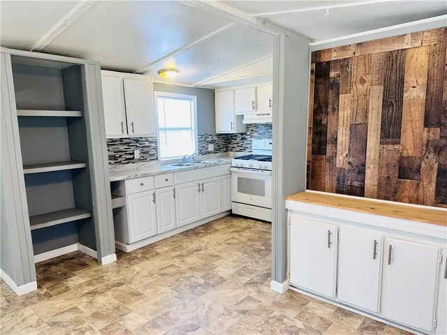 a kitchen with white cabinets and sink