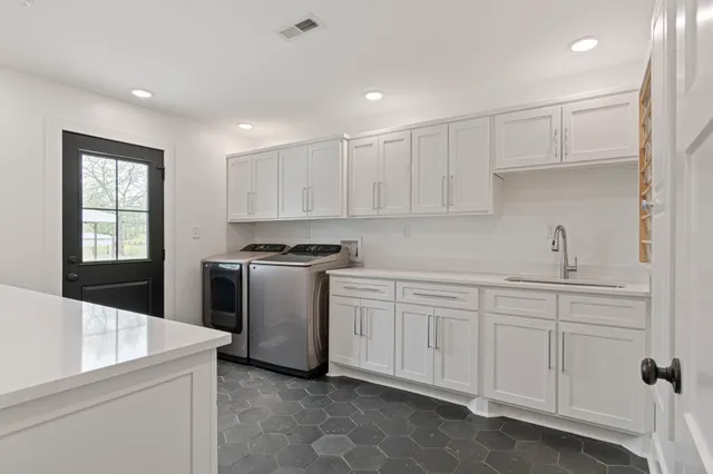 a kitchen with white cabinets and sink