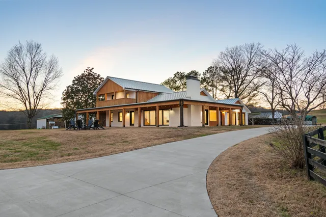 a front view of a house with a yard and trees