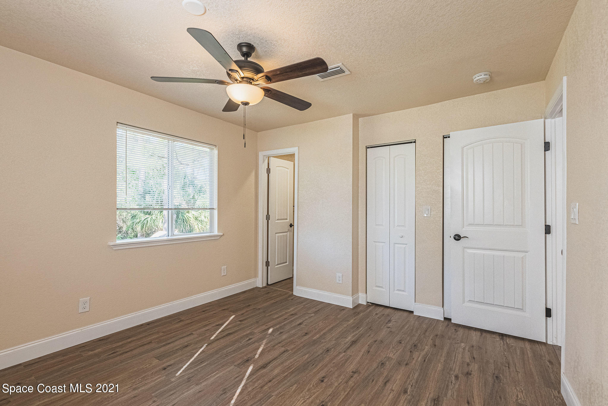 765 Garvey Road Palm Bay, FL 32908 - Photo 28 of 81 a view of an empty room with wooden floor and a window