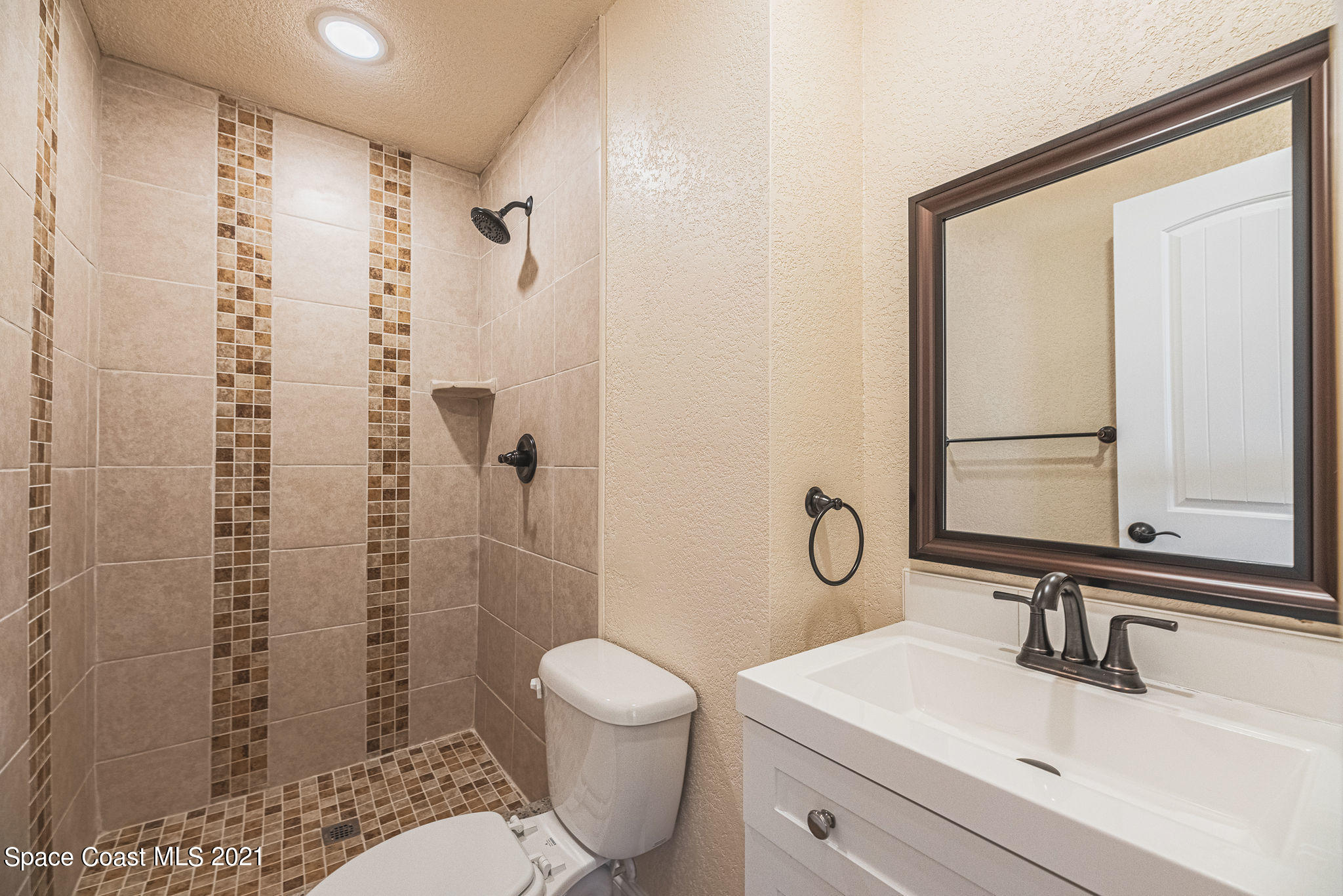 765 Garvey Road Palm Bay, FL 32908 - Photo 30 of 81 a bathroom with a granite countertop toilet a sink and a mirror