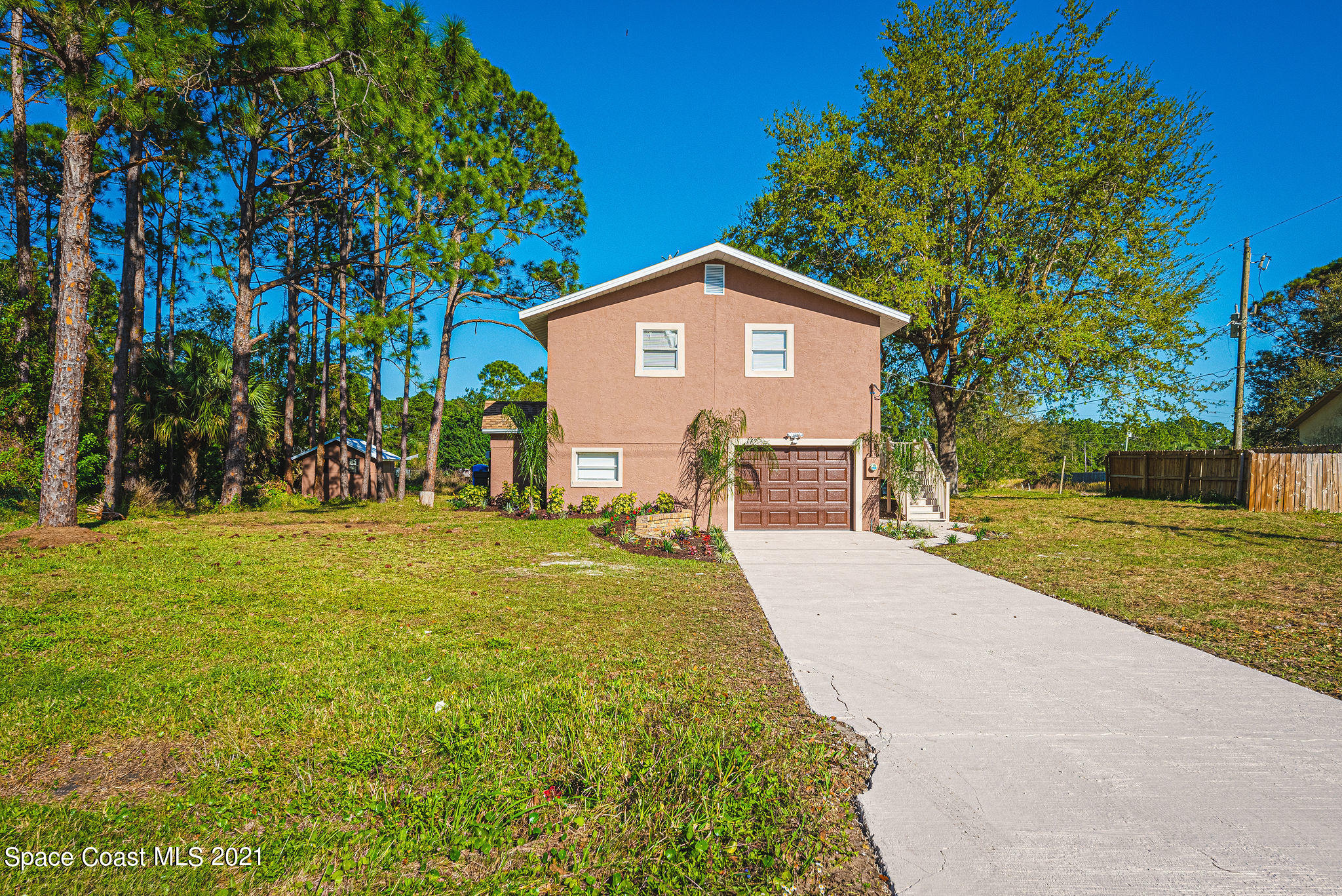 765 Garvey Road Palm Bay, FL 32908 - Photo 4 of 81 a view of a yard in front of a house with a large tree