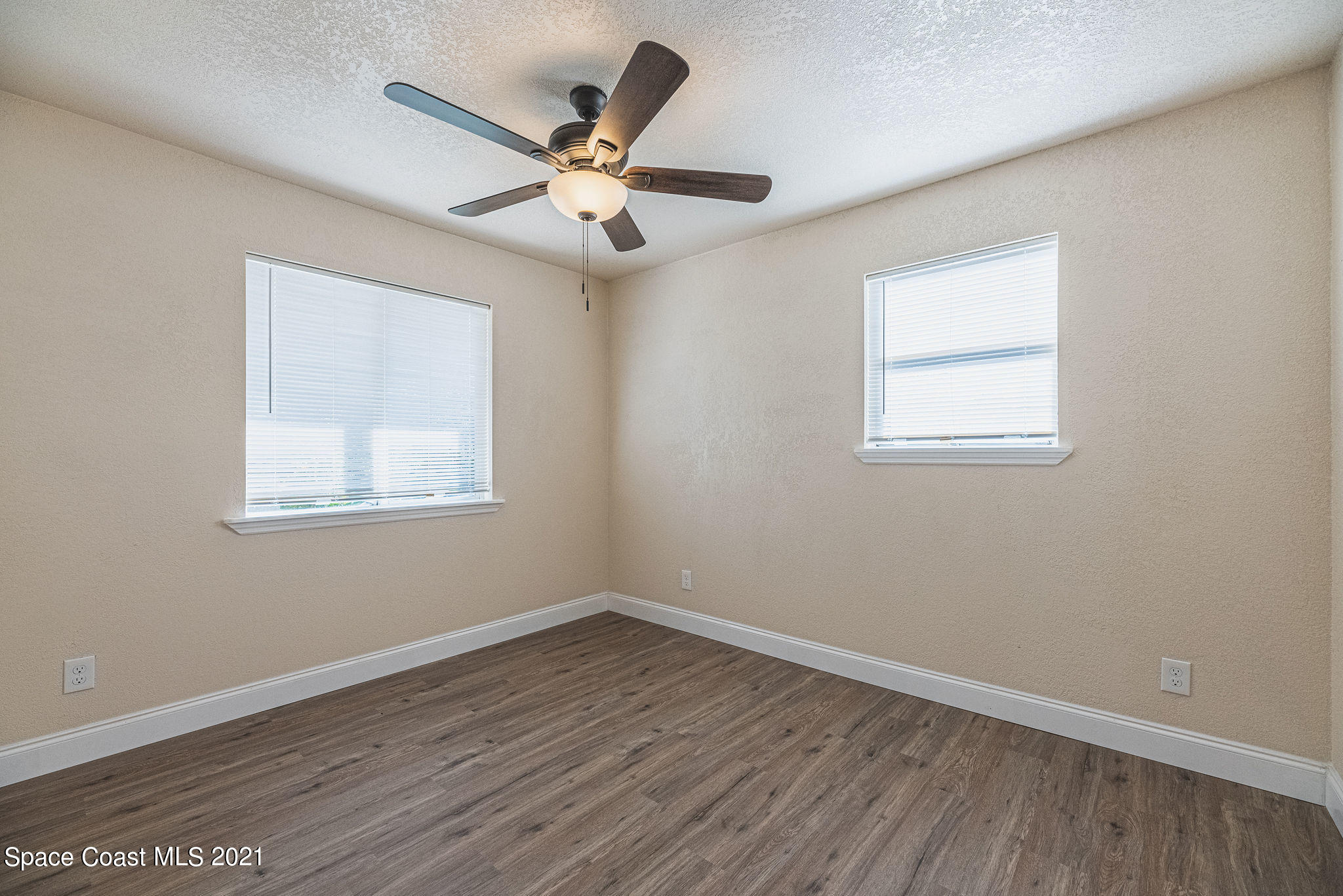 765 Garvey Road Palm Bay, FL 32908 - Photo 35 of 81 an empty room with wooden floor fan and windows