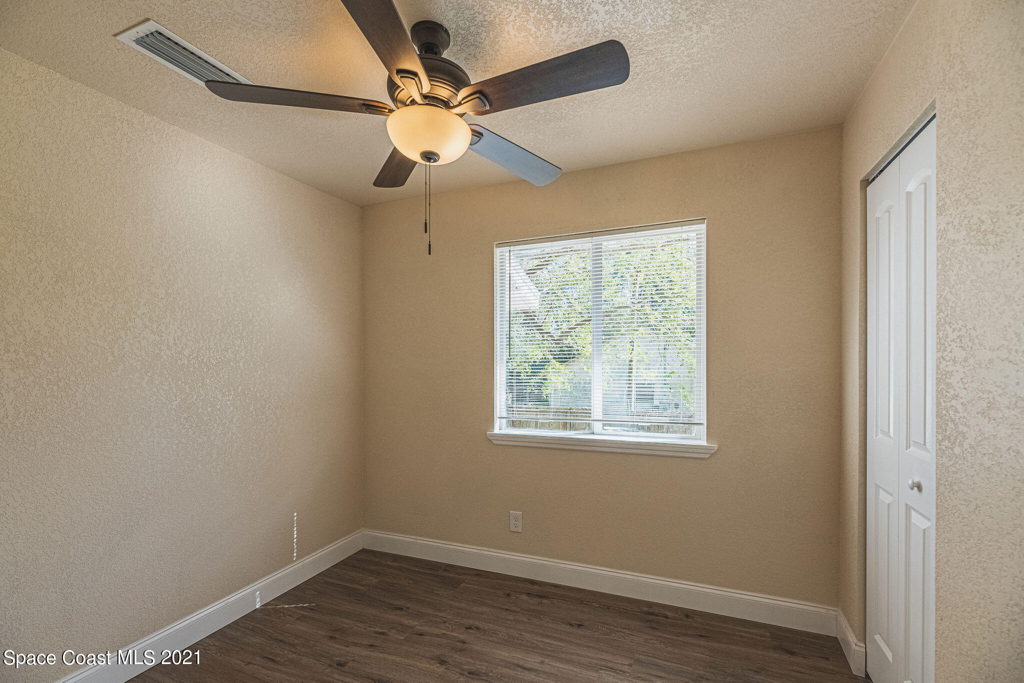 765 Garvey Road Palm Bay, FL 32908 - Photo 37 of 81 an empty room with wooden floor fan and windows