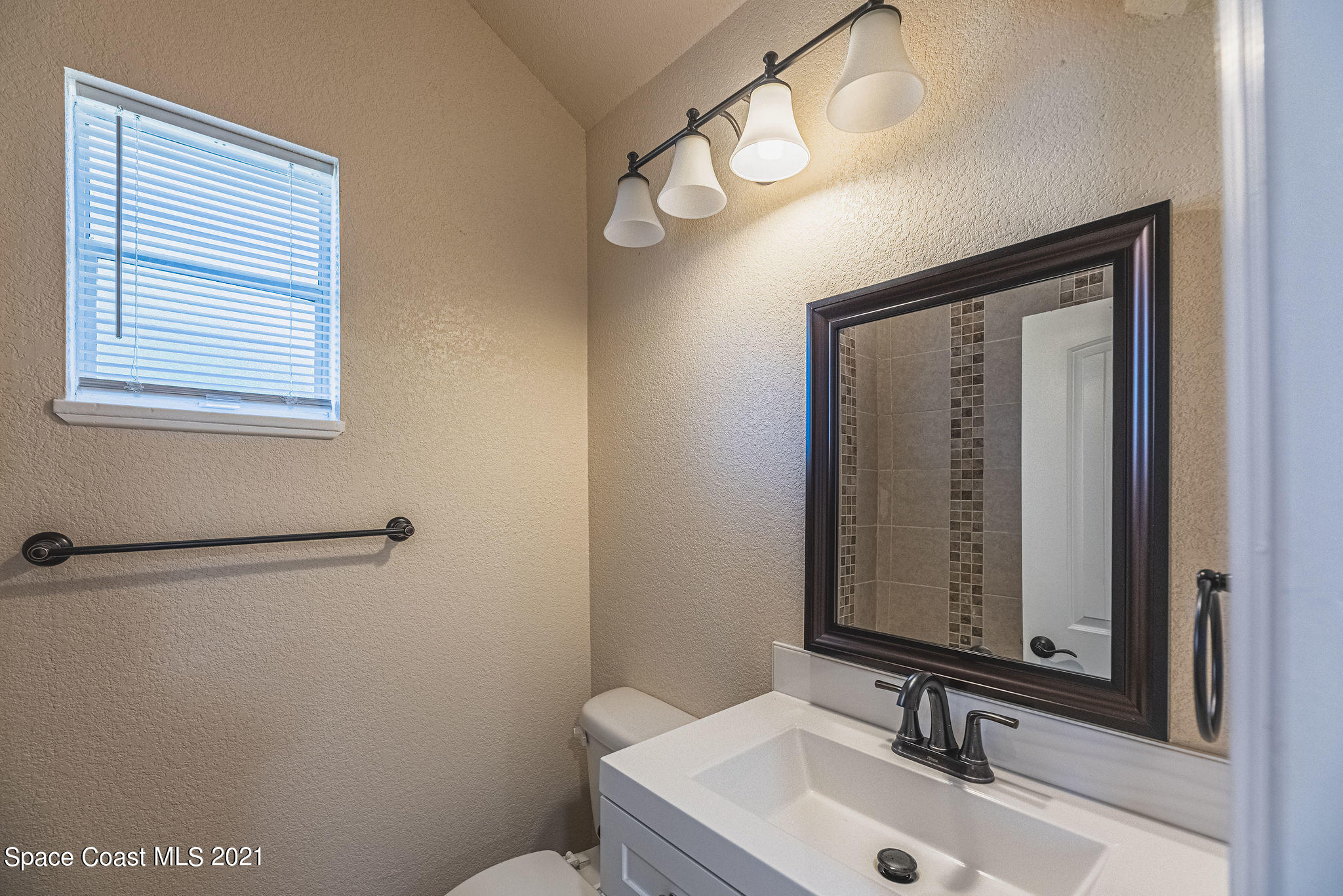 765 Garvey Road Palm Bay, FL 32908 - Photo 56 of 81 a bathroom with a sink a mirror and a toilet
