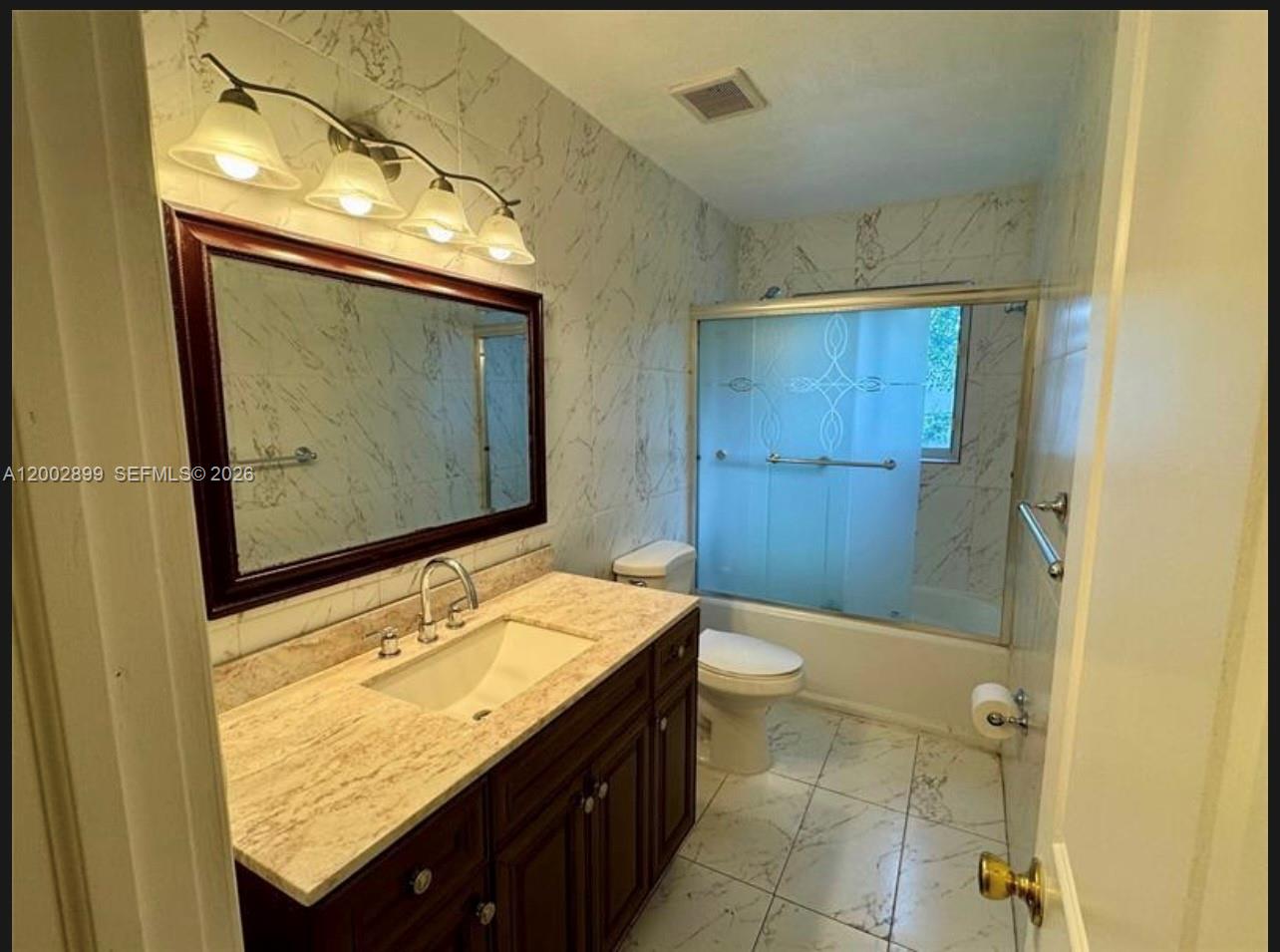 6471 Southwest 27th Street, Unit 1 & 2 Miramar, FL 33023 - Photo 11 of 29 a bathroom with a granite countertop sink toilet and shower