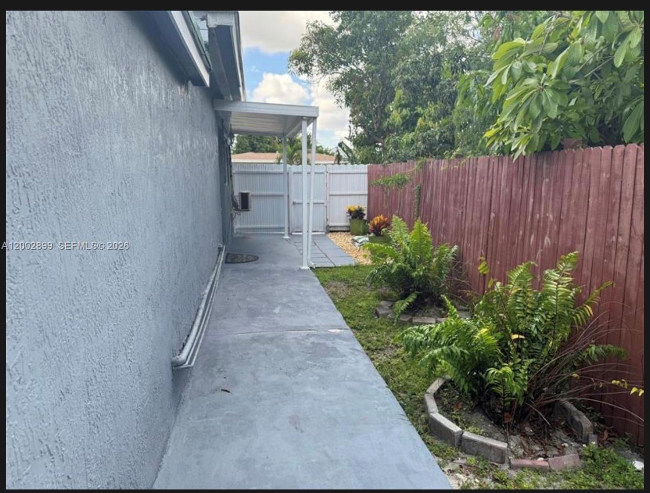 6471 Southwest 27th Street, Unit 1 & 2 Miramar, FL 33023 - Photo 17 of 29 a backyard with potted plants and wooden fence