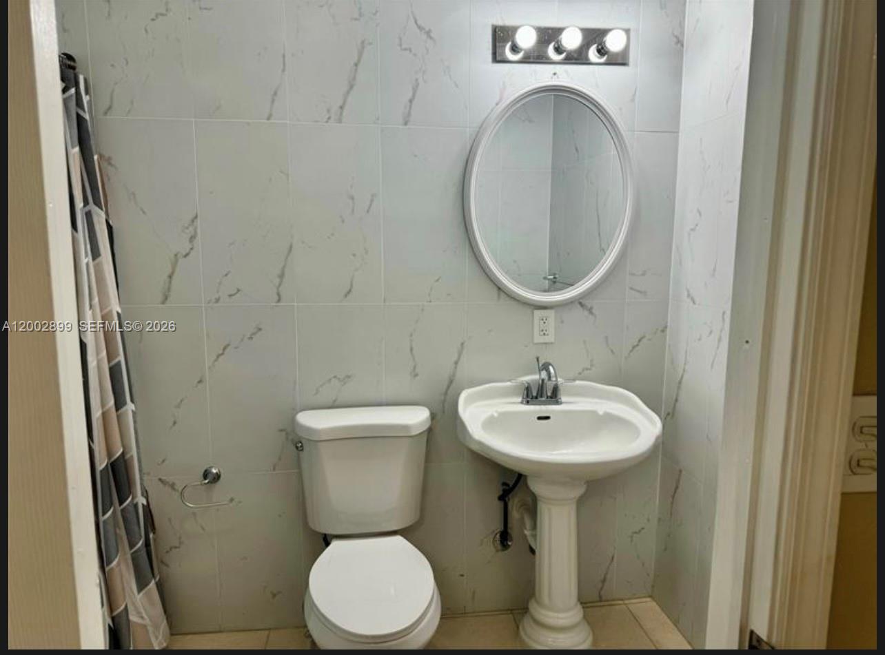 6471 Southwest 27th Street, Unit 1 & 2 Miramar, FL 33023 - Photo 9 of 29 a bathroom with a toilet sink and mirror