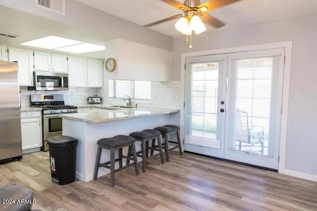 a kitchen with stainless steel appliances granite countertop a stove a refrigerator a sink a microwave oven with a dining table and chairs