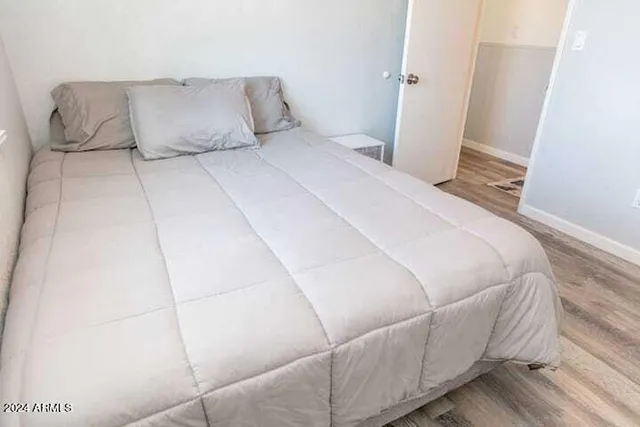 a large bed sitting in a bedroom next to a window