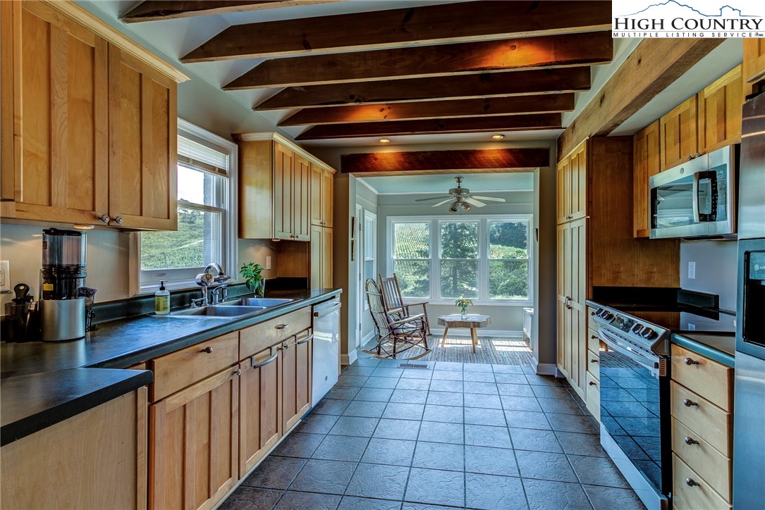 1046 J E Gentry Road Laurel Springs, NC 28644 - Photo 15 of 49 a kitchen with stainless steel appliances granite countertop a stove a sink and a microwave
