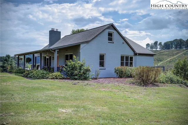a view of a house with a big yard and a large tree