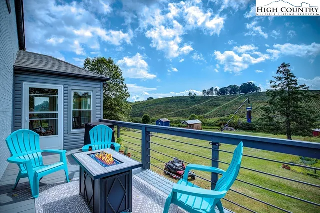 a porch with a table and chairs and potted plants