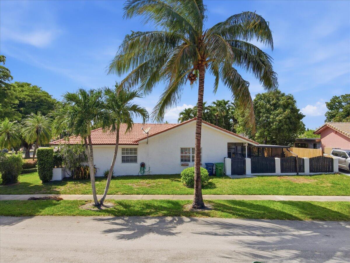 20009 Northwest 66th Place Hialeah, FL 33015 - Photo 4 of 33 a view of a white house with a big yard and palm trees