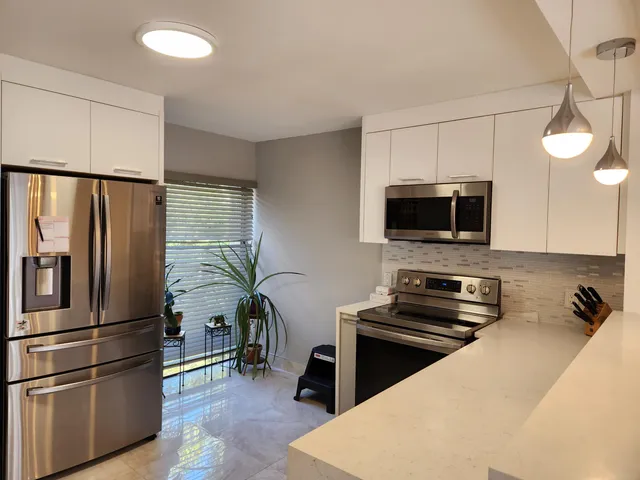 a kitchen with stainless steel appliances a stove a refrigerator and a microwave