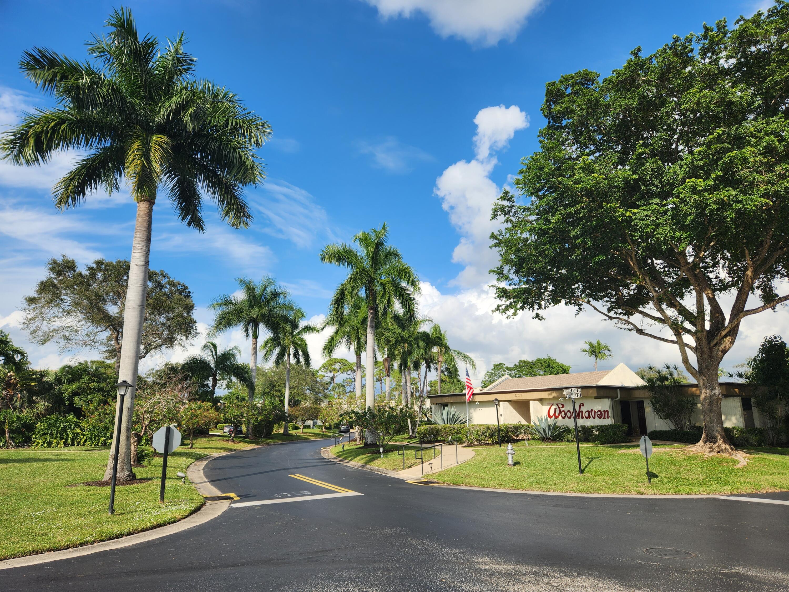 6557 Burning Wood Drive, Unit 215 Boca Raton, FL 33433 - Photo 22 of 22 a palm tree sitting in front of a house with a big yard