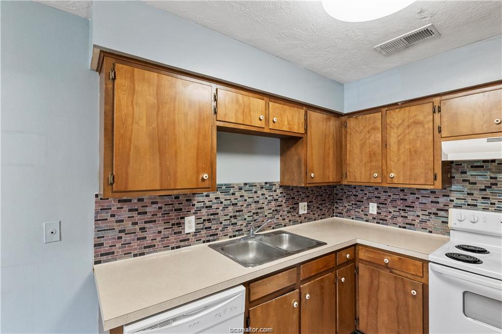 609 Wades Way, Unit 4 Navasota, TX 77868 - Photo 8 of 12 a kitchen with a sink and a stove top oven