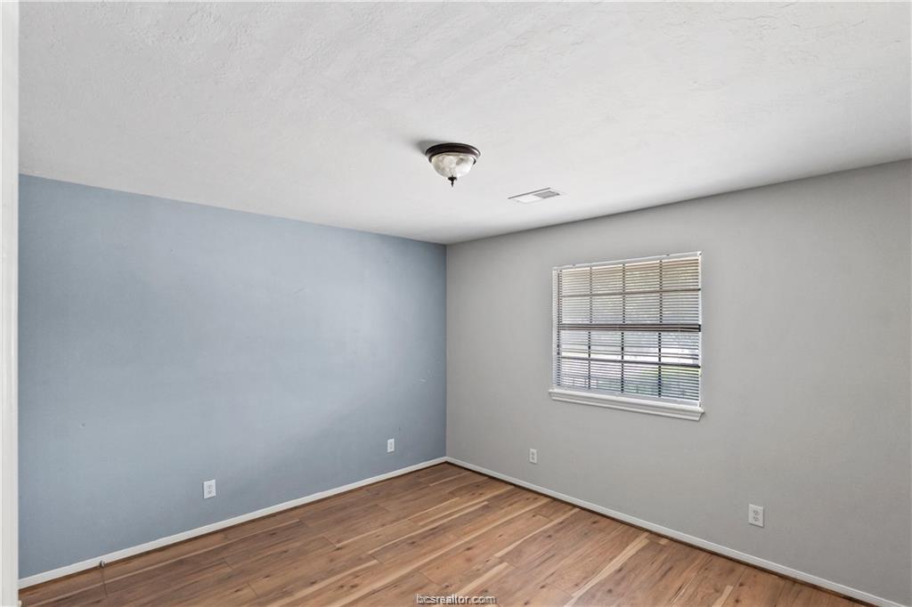 609 Wades Way, Unit 4 Navasota, TX 77868 - Photo 10 of 12 an empty room with wooden floor and windows