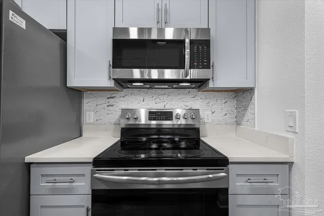 a kitchen with stainless steel appliances a stove a microwave and a refrigerator