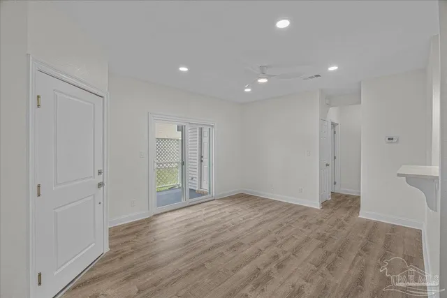 a view of a hallway with wooden floor and a bathroom