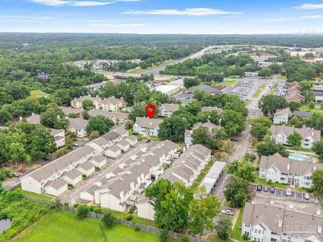 an aerial view of residential houses with outdoor space and trees
