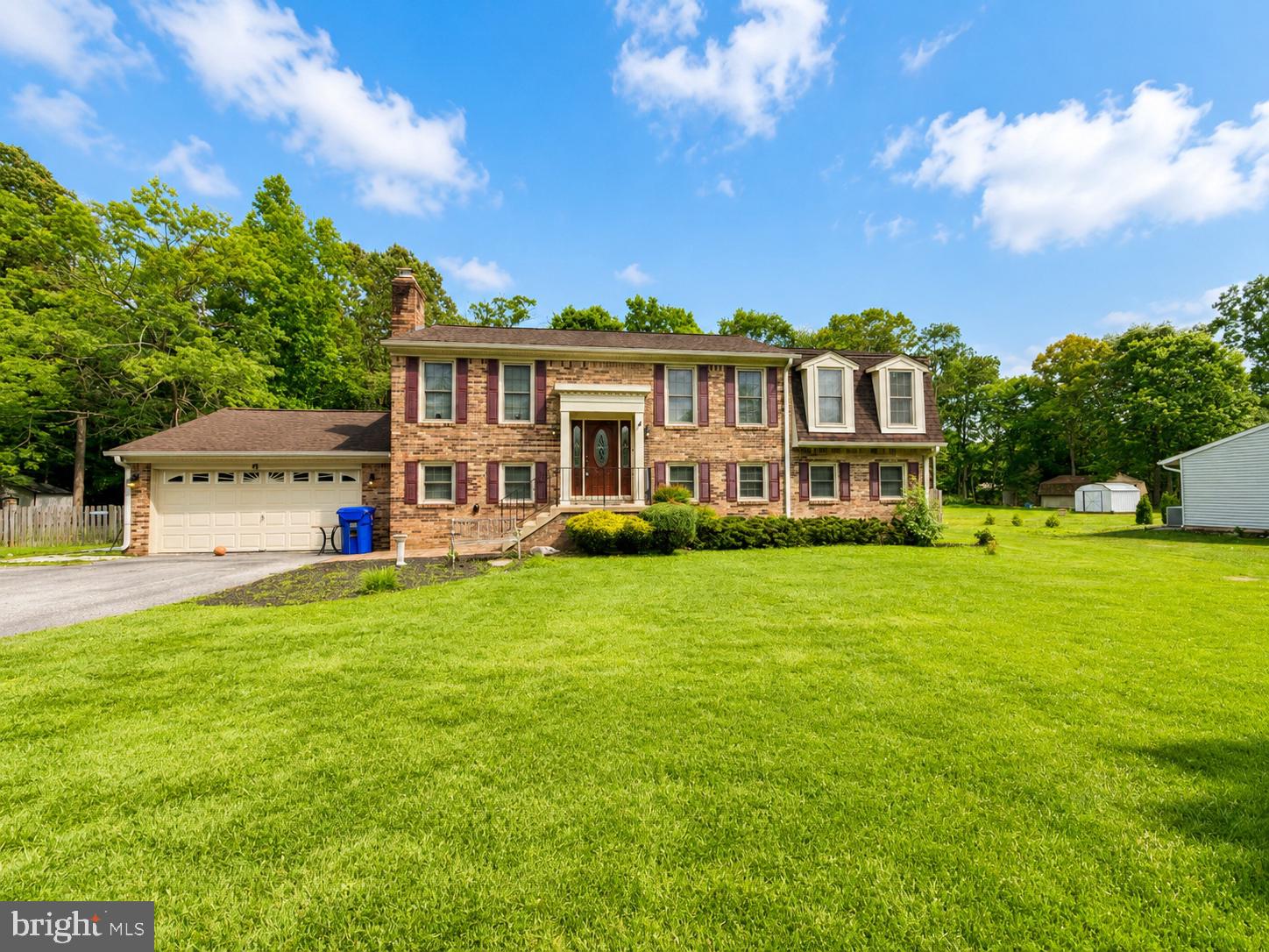 Charming brick home on lush green lawn.