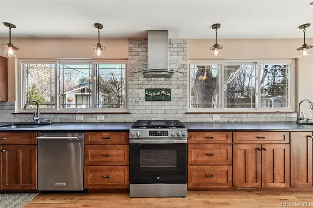 a large kitchen with granite countertop a stove and a wooden floors