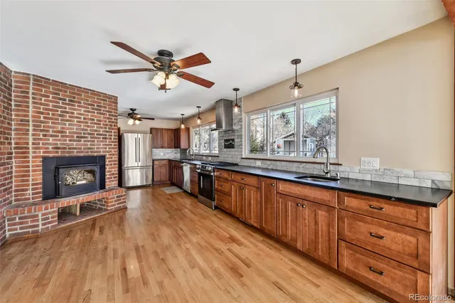 a large kitchen with kitchen island a large counter space a sink a window and stainless steel appliances