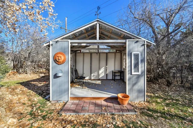a view of a yard with plants and large trees