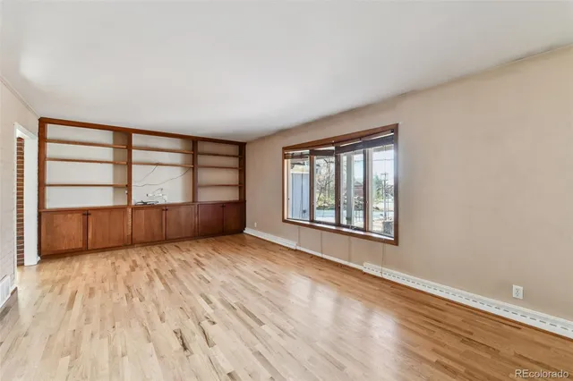 wooden floor in an empty room with a window