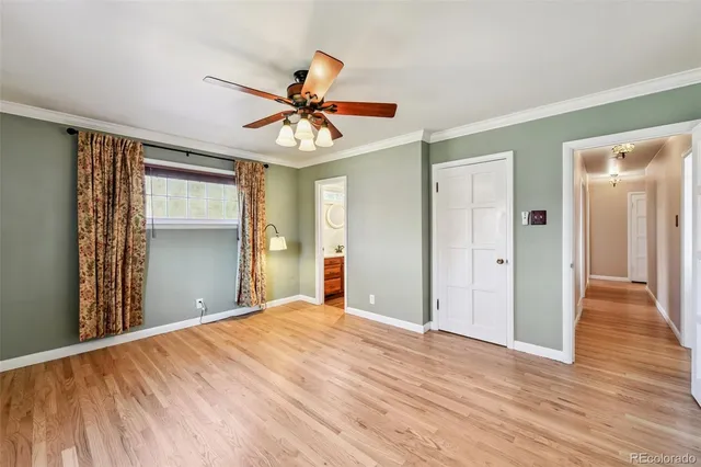 a view of a room with wooden floor and ceiling fan