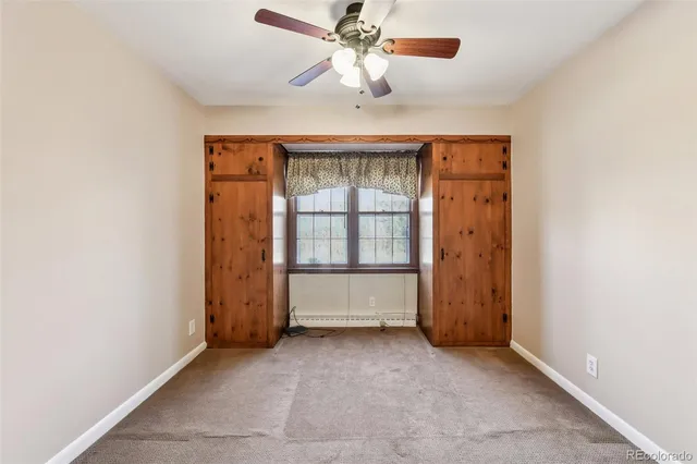 an empty room with chandelier fan