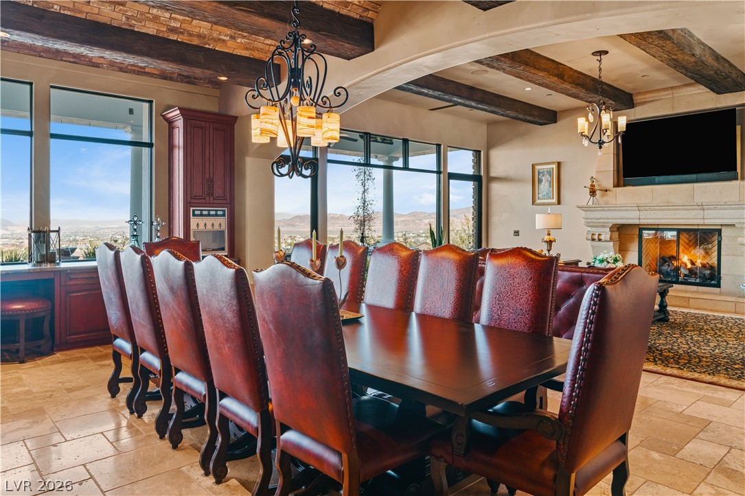 1123 Christian Road Henderson, NV 89002 - Photo 15 of 94 Gather around this dining space, offering panoramic views and a grand stone fireplace for memorable evenings.