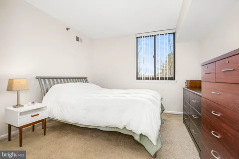 a bedroom with a bed and a lamp