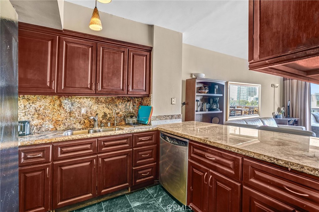 969 Hilgard Avenue, Unit 706 Los Angeles, CA 90024 - Photo 7 of 27 a kitchen with granite countertop stainless steel appliances and wooden cabinets