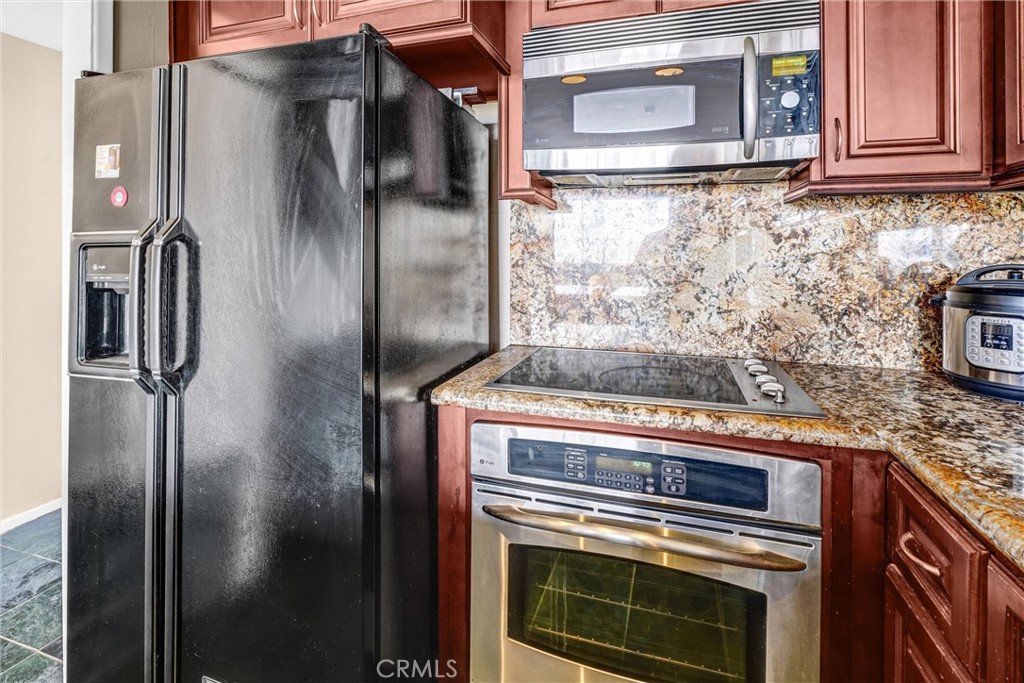 969 Hilgard Avenue, Unit 706 Los Angeles, CA 90024 - Photo 9 of 27 a kitchen with granite countertop a refrigerator and stove