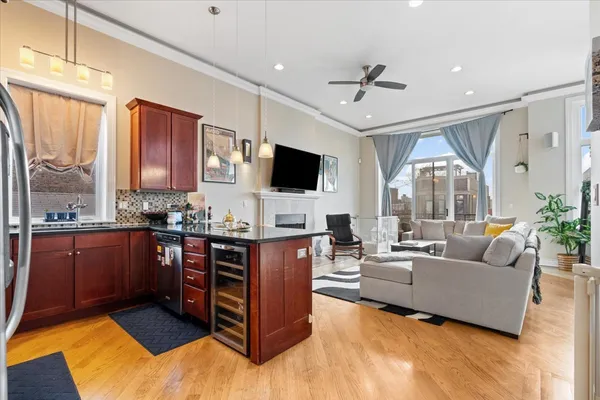 a living room with stainless steel appliances granite countertop furniture a flat screen tv and a large window