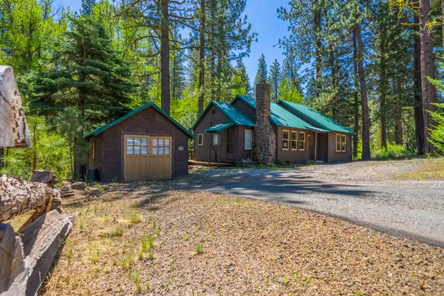 a front view of a house with a yard and trees